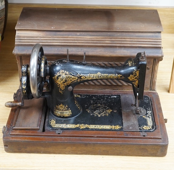 An early 20th century cased Singer sewing machine, 46cm wide at base. Condition - poor